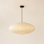 Akari EN oval washi paper pendant with black cord on a warm neutral background