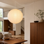 Akari round paper globe swag light, Dia 47.2 by H 46.5 inches, in a high-ceiling walnut interior