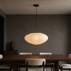 Akari A oval washi paper pendant light with black cord in a warm interior