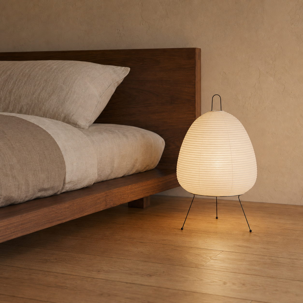 Akari Model A1 Japanese paper lantern floor lamp beside a low bed